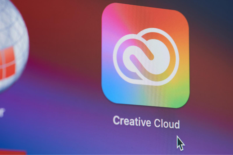 Graphic design software Creative Cloud app icon on computer screen with rainbow gradient background.