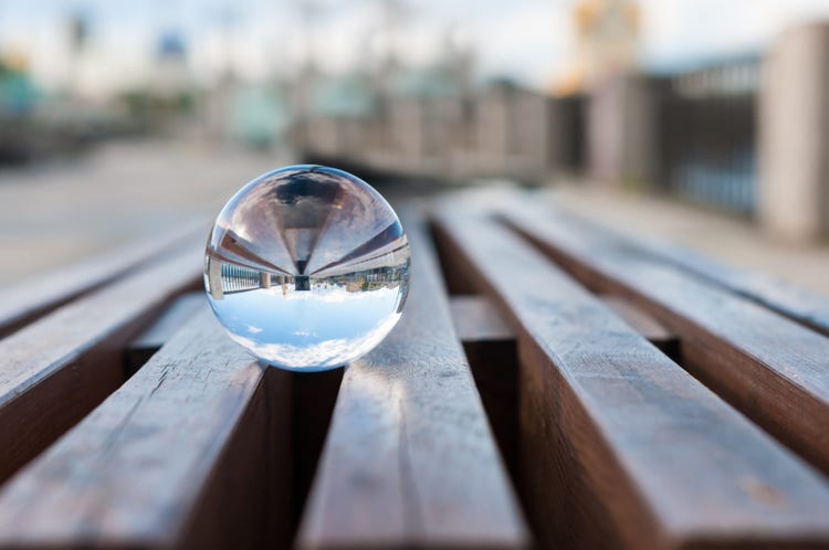 Glass transparent ball on wooden slats background.
