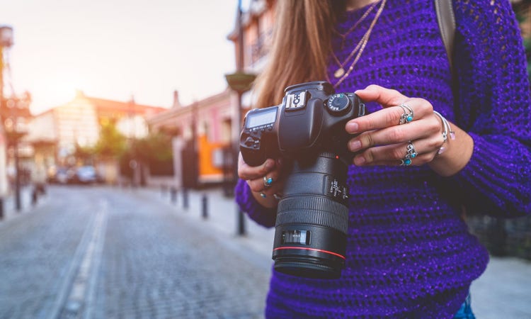 A woman taking pictures with digital dslr camera and slr lens.