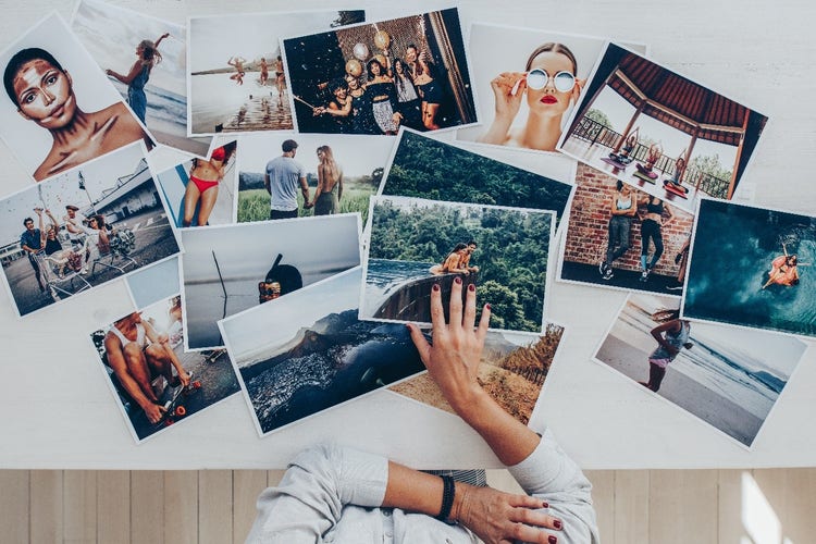 Range of photos on a table with a person looking at the selection options.