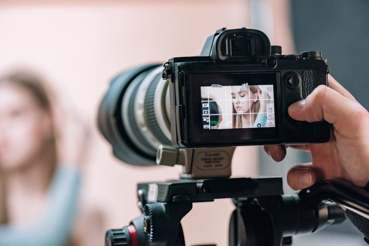 Camera display showing a focused model in a photo studio, illustrating photography basics like composition and depth of field.