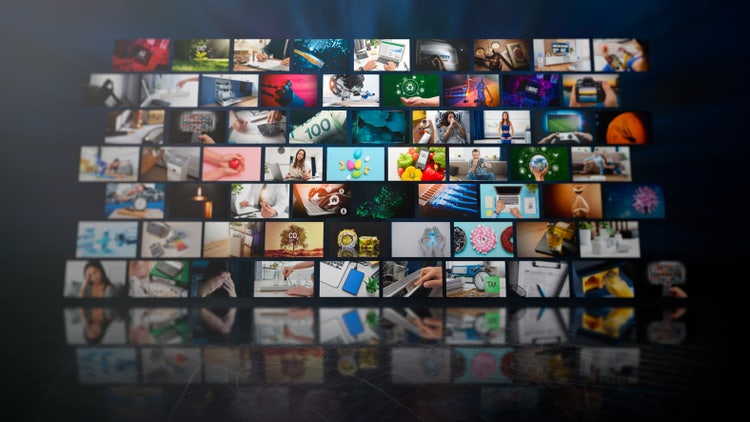 A digital display wall featuring dozens of video thumbnails representing diverse content, symbolising the power of video AI in generating and organising multimedia at scale.