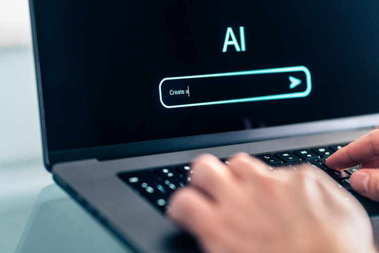 Person entering a prompt in an AI video generator interface on a laptop