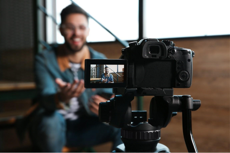 Professional camera on tripod recording a man creating video content for business marketing and social media.