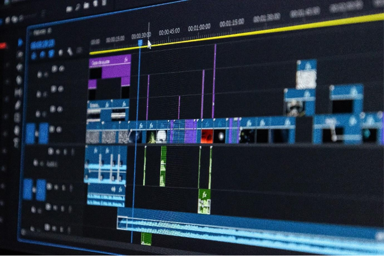 A closeup image of a computer monitor displaying a video editing timeline filled with clips, audio, and effects.