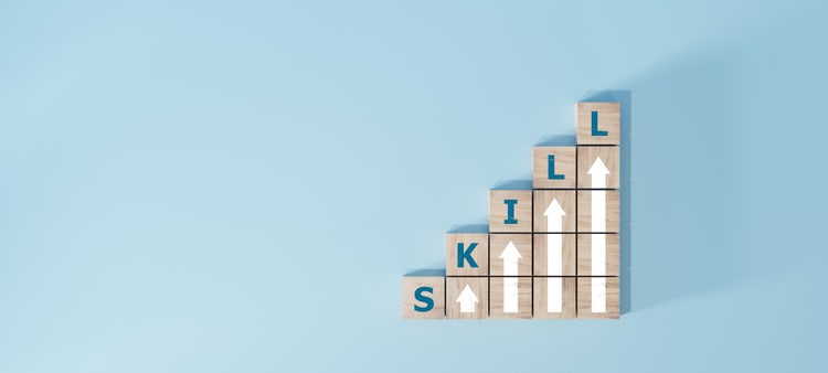 Wooden blocks spelling skill with upward arrows, symbolizing ai-driven skill growth on blue background