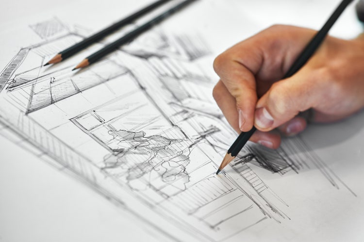 Hand drawing an architectural sketch with pencil.