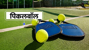 कोर्ट पर पिकलबॉल पैडल और गेंदें, 'सोशल के लिए तैयार हों' का प्रतिनिधित्व करते हुए।