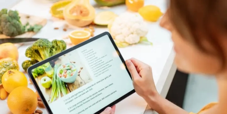 Tablet con ricettario digitale mentre si preparano ingredienti freschi