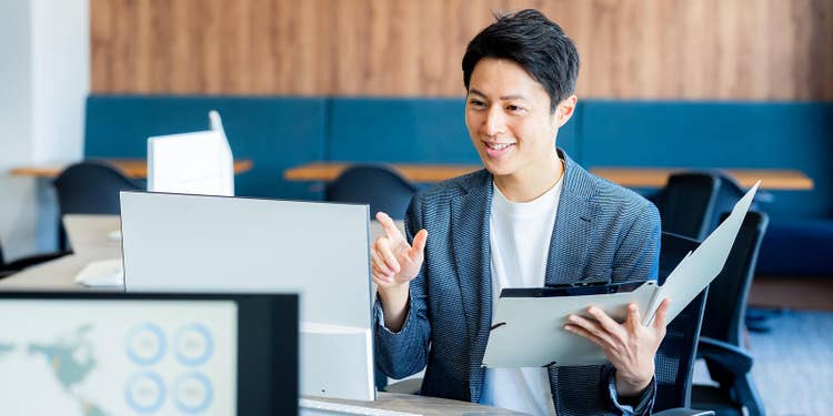 紙書類とPCを見合わせて指差し確認している様子