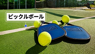 コートに置かれたピックルボールのラケットとボール。SNS投稿用に準備ができていることを表している。