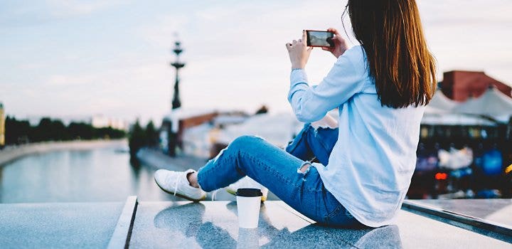 風景をスマートフォンで撮影する人