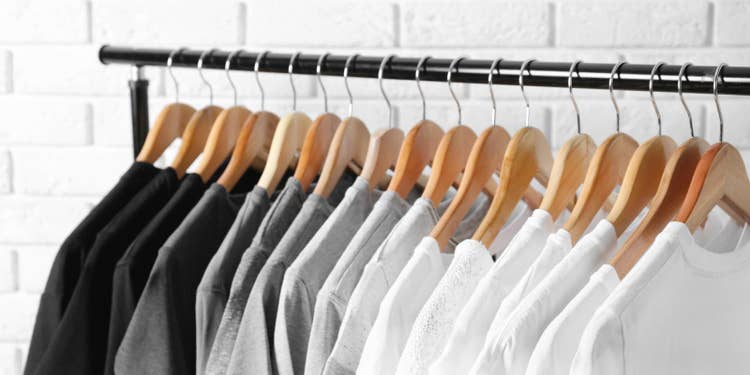 ハンガーラックに吊るされた黒、グレー、白のTシャツ