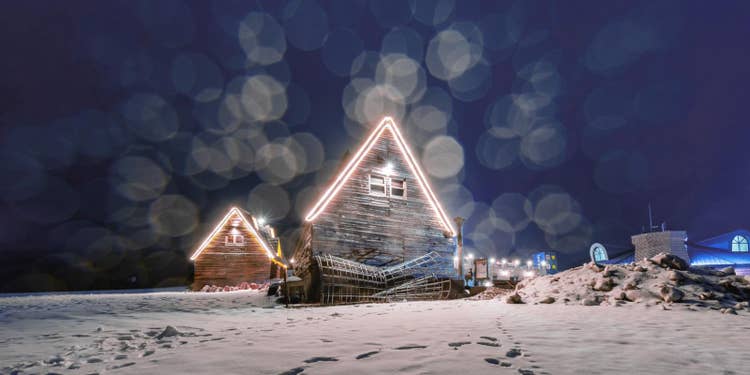 雪の夜、ネイビーの空の下に建つ2軒のログハウス