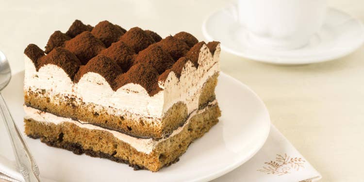 白いテーブルに、白皿に乗せたティラミスと白いティーカップ