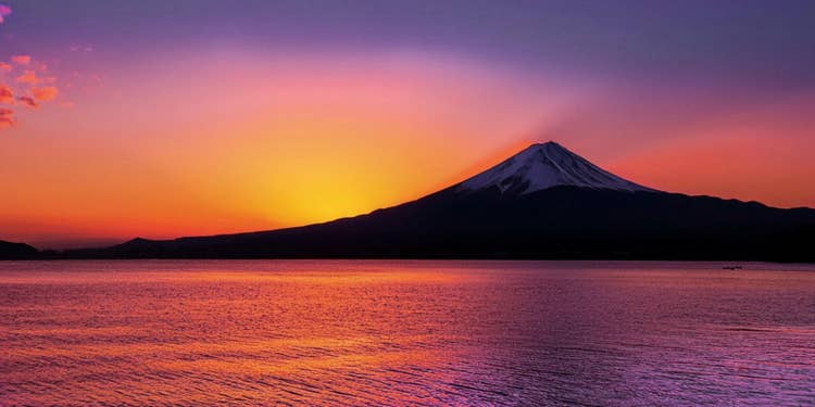 夕暮れ時の富士山。紫、オレンジ、赤の空と海