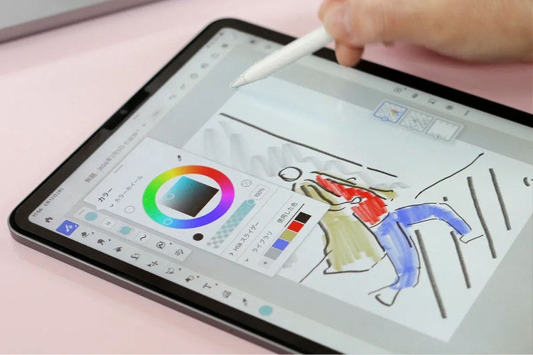 タブレット端末でイラストを描いている様子。スタイラスペンを使って人物のスケッチに色を塗っており、画面にはカラーホイールやブラシ設定などの描画ツールが表示されている。