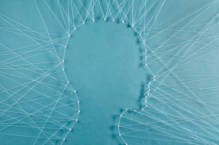 Pins with strings connecting them and shooting outward to create the outline of a person's side portfolio