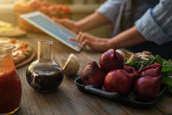 준비된 요리 재료와 태블릿 요리 레시피를 확인하는 모습