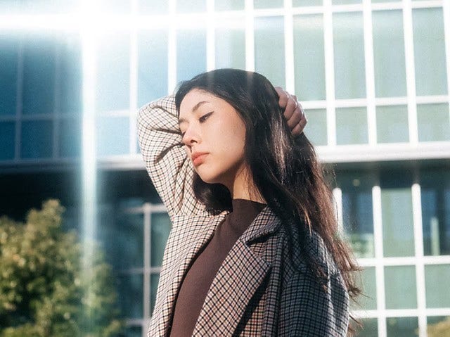 유리 건물 앞의 여성