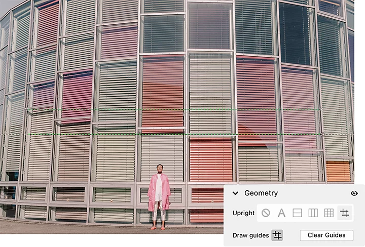 A person standing in front of a building with colorful curtains and the Adobe {{lightroom}} Geometry windowpane superimposed over it