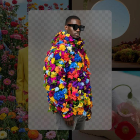 Person wearing sunglasses and a vibrant coat covered in multi-coloured flowers with a transparency grid background.