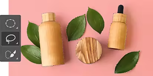 Attēls ar vairākām augu lapām un koka pudelēm, kas atlasītas lietotnē Adobe Photoshop, izmantojot rīku Lasso (Laso)