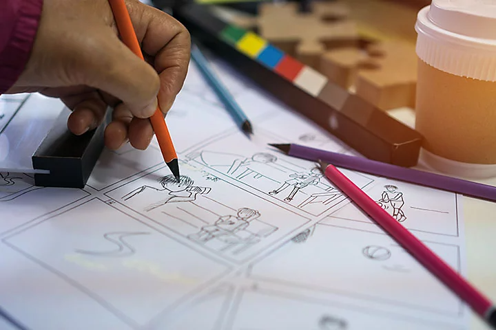 Close up of person drawing an animation storyboard with a pencil.