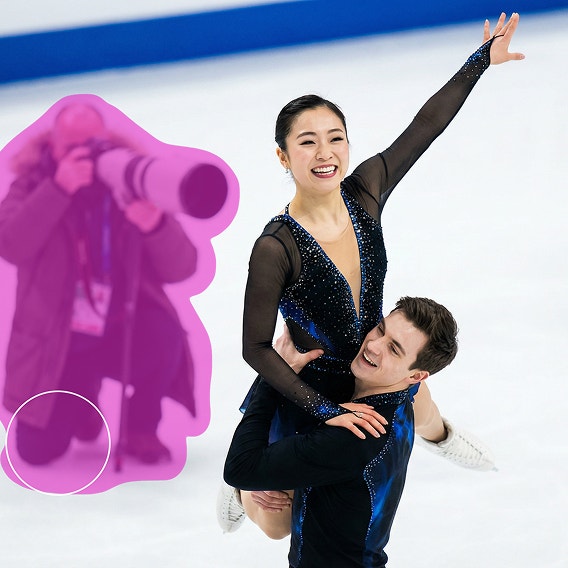 Een mannelijke kunstschaatser tilt een vrouwelijke kunstschaatser op; een te dichtbij staande fotograaf is gemarkeerd om uit de afbeelding te worden verwijderd.