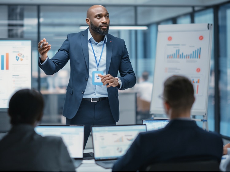 A photorealistic image of a businessman in a blue suit giving a presentation made with Firefly generative AI.