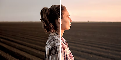 A portrait photo of a person standing in a field at dusk, with the Adobe {{lightroom}} &quot;Aged Photo&quot; preset applied to the right half of the photo