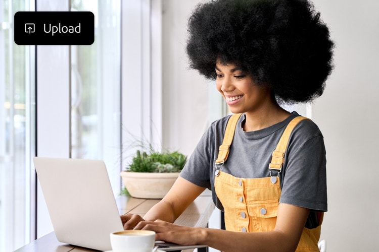 nakababatang propesyonal na nag-a-upload ng Audio file sa AI na tool sa pagsasalin habang nakaupo sa coffee shop
