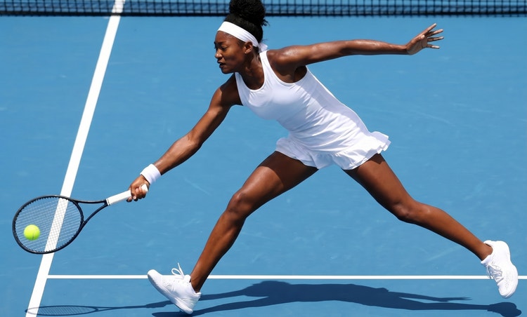 Woman hitting tennis ball on blue tennis court