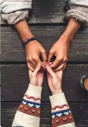 A close up image of a couple holding hands