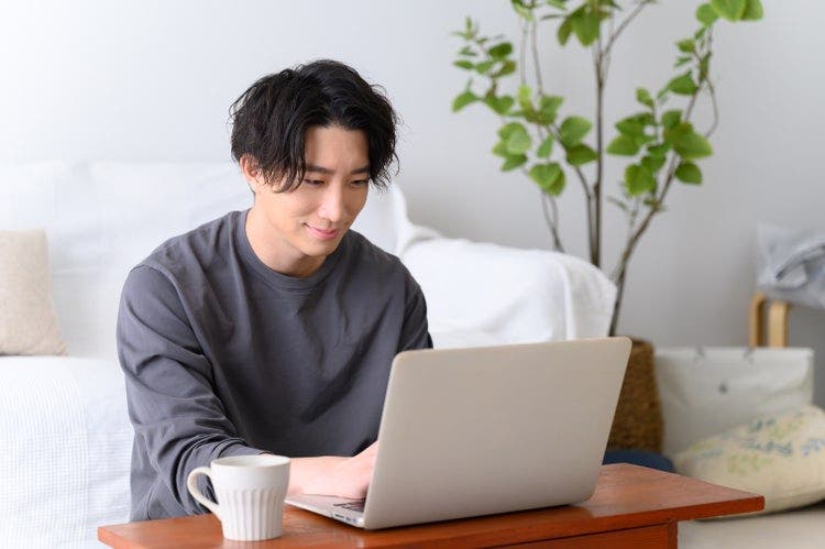 Um homem numa sala de estar a utilizar um portátil para dividir páginas do Google Docs.