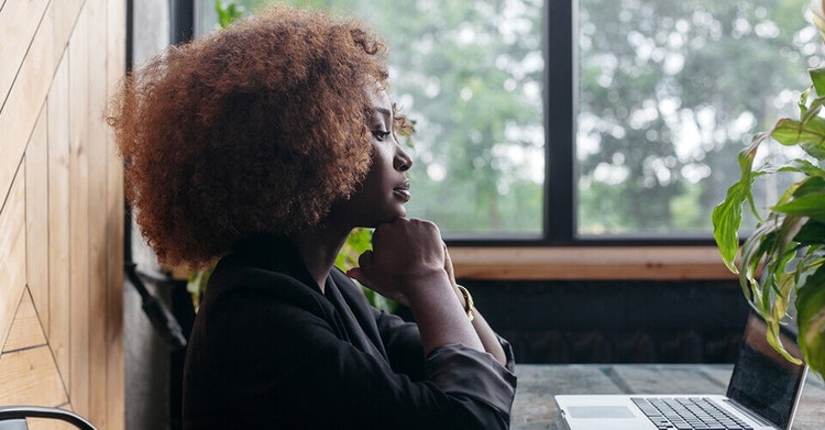 Uma pessoa a rever uma carta de motivação num portátil numa mesa