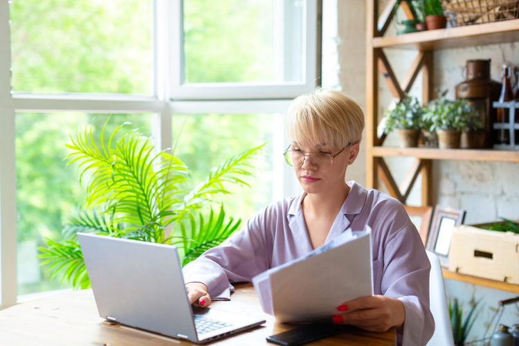 A woman in a living room uses her laptop to create a liability waiver form.