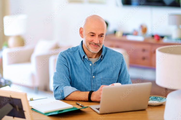 A man searches on his laptop to learn why to use RFP software for proposals.