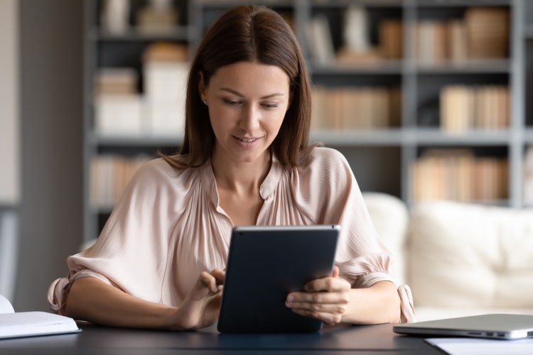 A woman uses her tablet to learn the difference between an invoice versus a receipt.