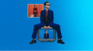 A woman in an orange suit sits on a chair in a field. The Photoshop AI Assistant is used to swap in a blue background, to replace the chair with TV, and change the suit's color to blue.