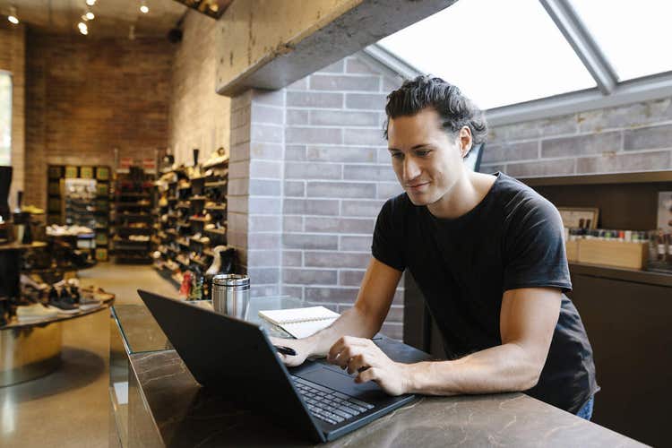 A person sitting at a table using their laptop