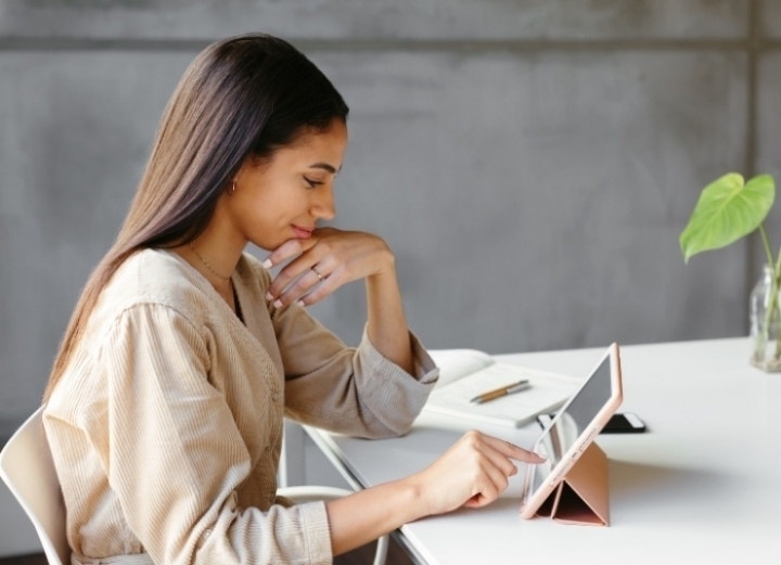 A person researching and outlining a business proposal on a tablet with Adobe Acrobat