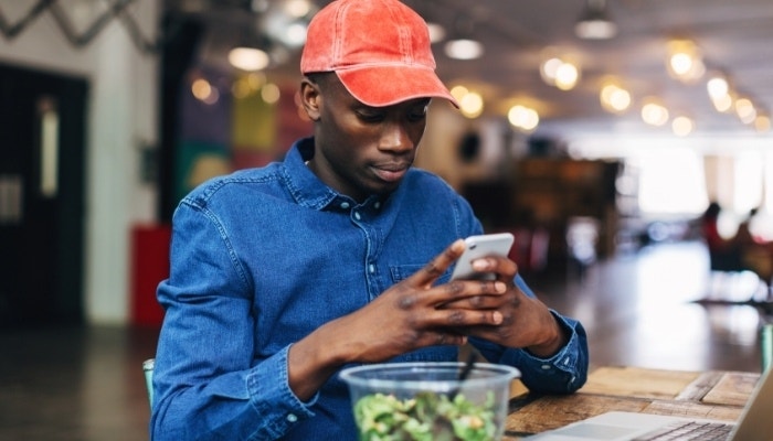 A freelance worker on their lunch break checking a PDF on their cell phone using Adobe Acrobat
