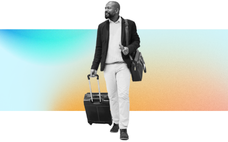 A man dressed in business casual attire carries a satchel and pulls a rolling suitcase