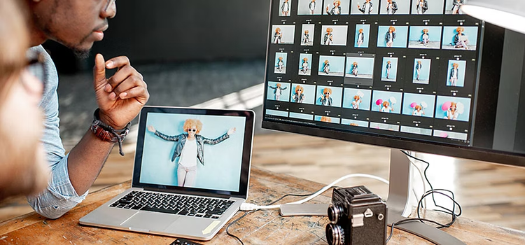 Two people editing photos using computer equipment