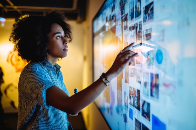 A woman looking over a light board full of images