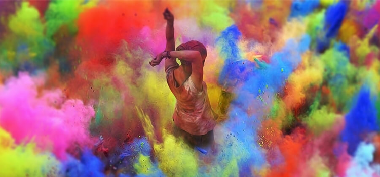 A woman stands in the middle of an explosion of colours.