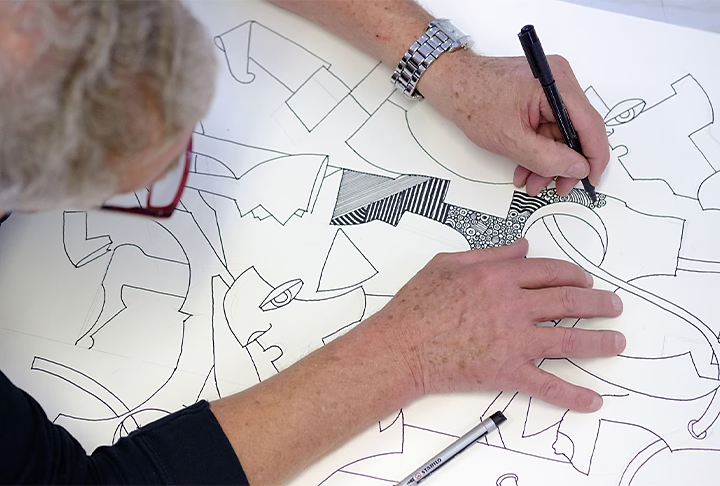 Một người đang vẽ một thiết kế nghệ thuật đường nét chi tiết
