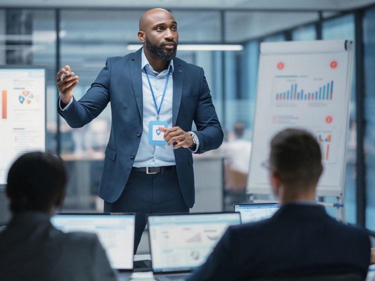 A photorealistic image of a businessman in a blue suit giving a presentation made with Firefly generative AI.